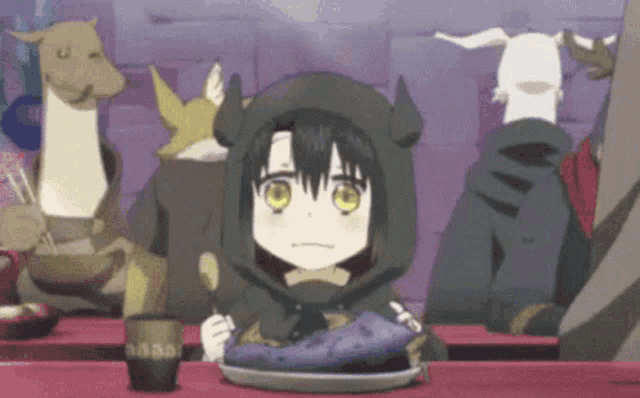 a little girl is sitting at a table with a plate of food and a spoon in her hand .