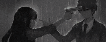 a girl is pointing a gun at a boy 's head .