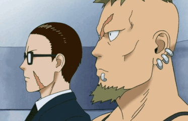 a man with a mohawk stands next to another man with piercings in his ears