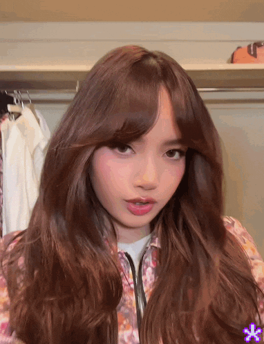 a woman with long brown hair is standing in a closet looking at the camera