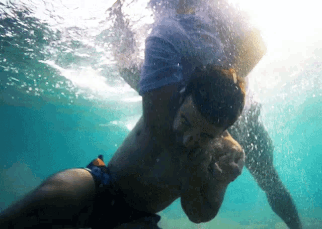 a man in blue shorts is swimming under water