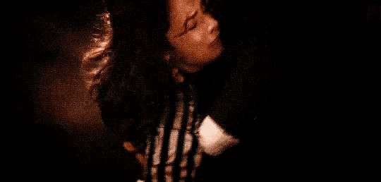 a man is holding a woman in his arms and they are kissing .