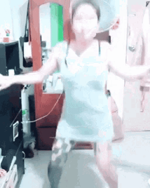a woman in a blue dress dancing in a room