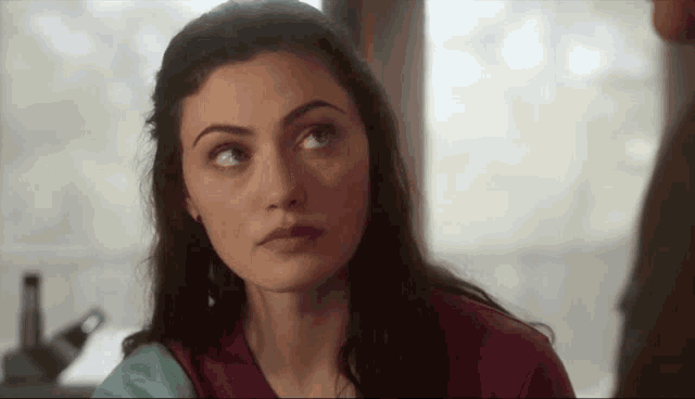 a close up of a woman 's face with a man in the background