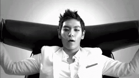 a man in a white suit is sitting in a chair