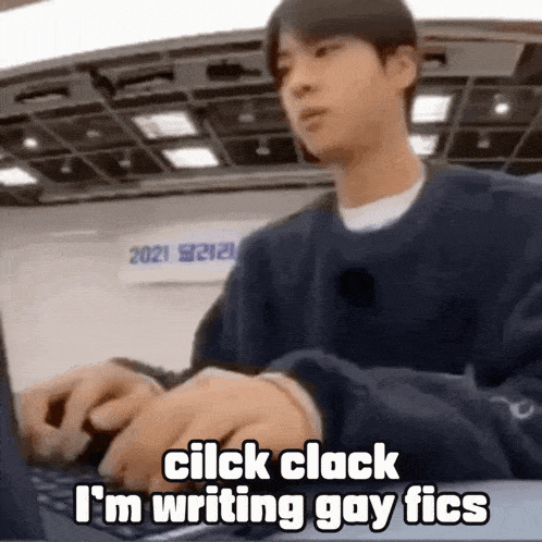 a man is typing on a laptop computer while sitting at a desk .