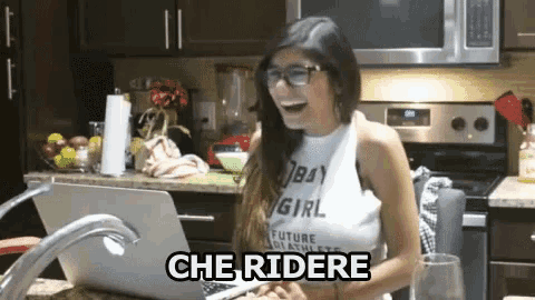a woman sitting in front of a laptop with the words che ridere written on the bottom