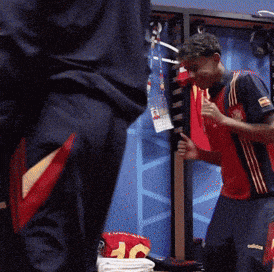 a man in a red adidas shirt stands in a dressing room