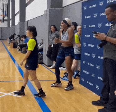 a group of people on a basketball court with a wall that says albert