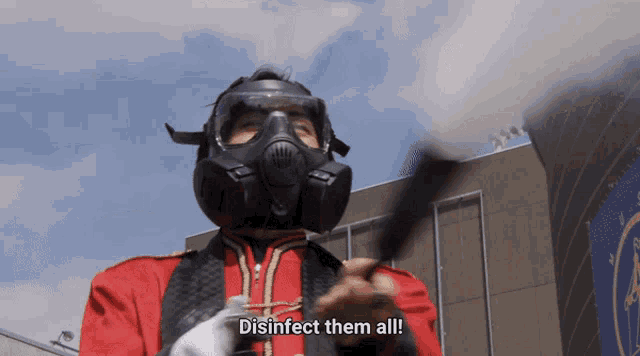 a man wearing a gas mask says " disinfect them all " in front of a building