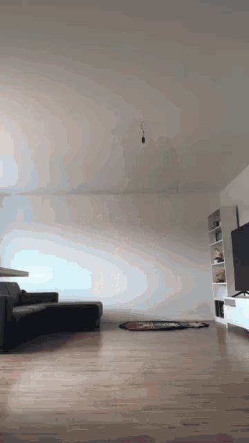 an empty living room with a couch and a television