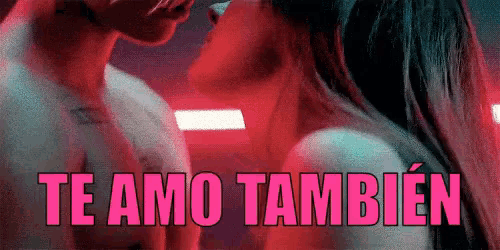a man and a woman are kissing in a dark room with the words `` te amo tambien '' written above them .