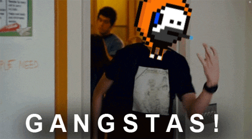 a man wearing a metallica shirt is standing in front of a wall that says gangstas
