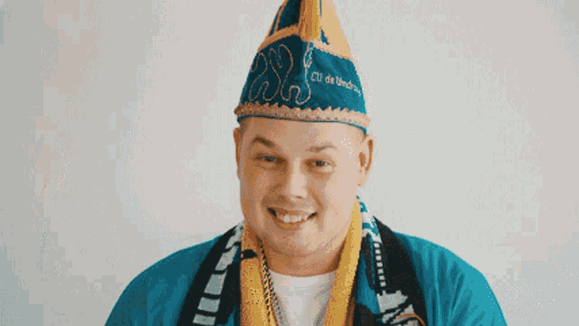 a man wearing a blue hat and a scarf that says club de unichru