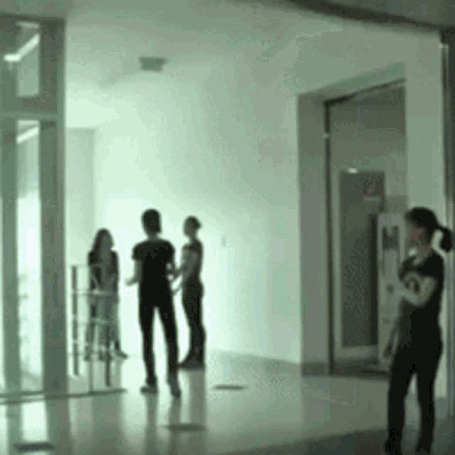 a group of people standing in a hallway talking