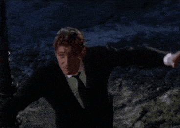 a man in a suit and tie is standing in a dark room