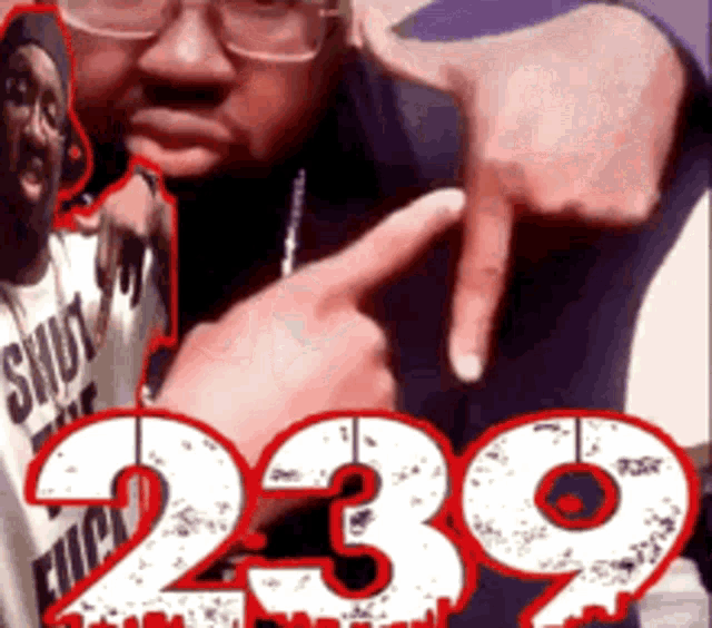 a man wearing glasses points at the number 239