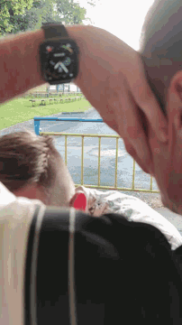 a man wearing an apple watch looks at another person
