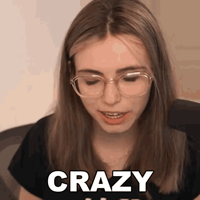 a woman wearing glasses and a black shirt with the word crazy on it
