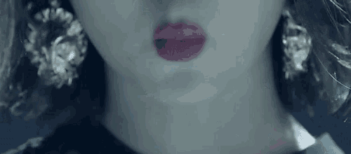 a close up of a woman 's mouth with red lipstick and earrings .
