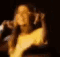 a blurry picture of a man holding a microphone in a dark room .