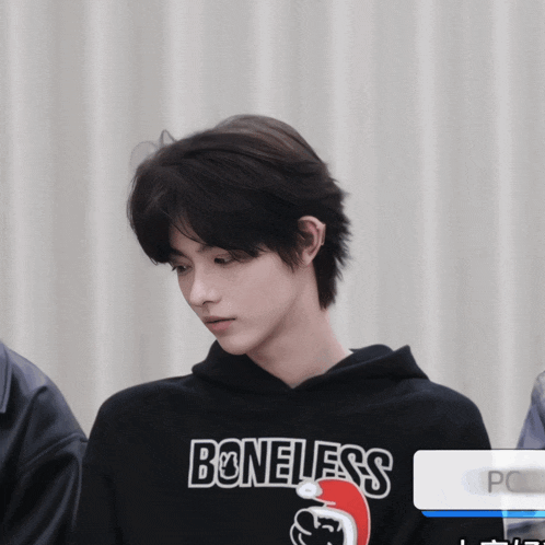 a boy wearing a black hoodie that says boneless on it