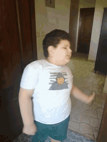 a boy wearing a white t-shirt with a picture of a wizard on it