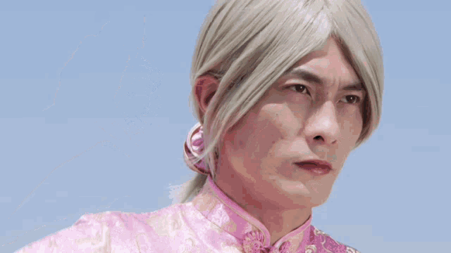 a man wearing a pink dress is holding a device that says ' ninja ' on it