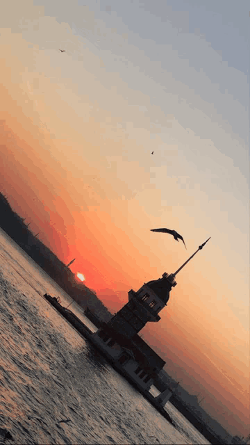 a sunset with a tower in the foreground