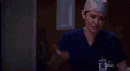 a female surgeon wearing a scrub top and a name tag with abc on it
