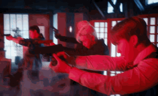 a group of people holding guns in red light