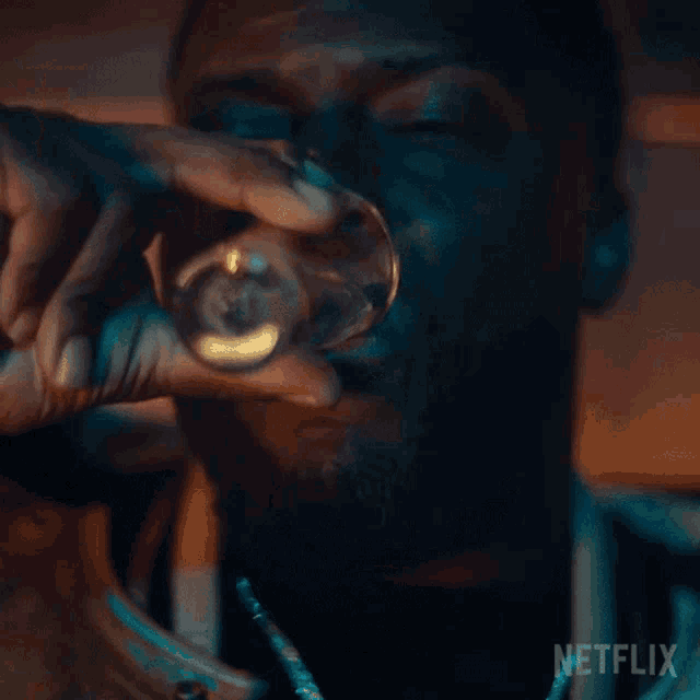 a man is drinking from a can with a netflix logo on the bottom