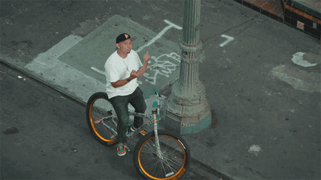 a man wearing a hat with the letter p on it sits next to a bicycle