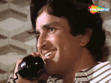 a man is smiling while talking on a phone with a watermark that says ' shemaroon ' on it