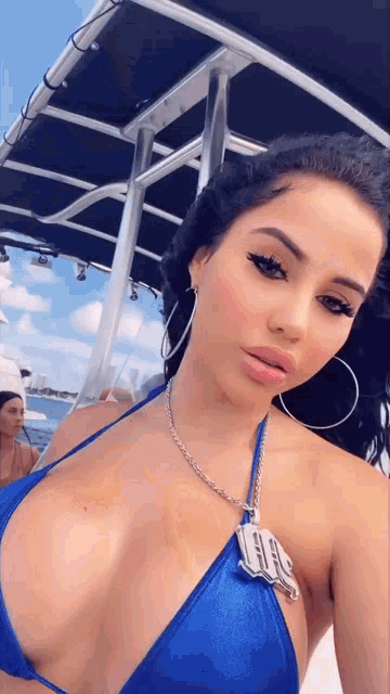 a woman in a blue bikini is taking a picture of herself on a boat .