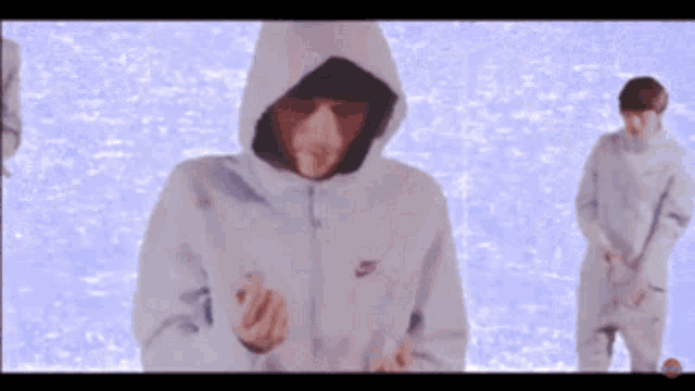 a man wearing a nike hoodie is standing in front of a purple background
