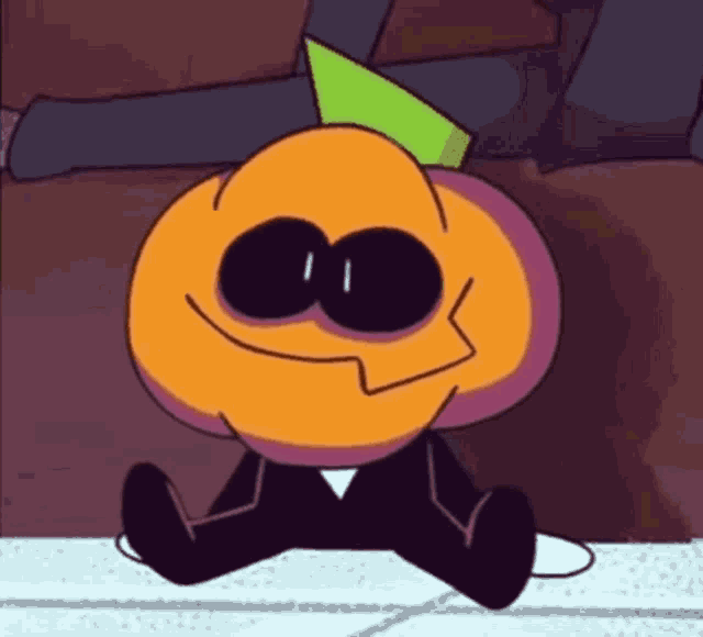 a cartoon pumpkin with a green hat is sitting on the floor and smiling .