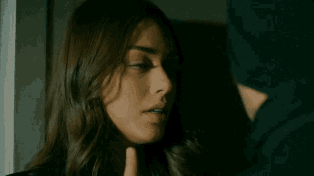 a close up of a woman 's face with a man 's hand on it