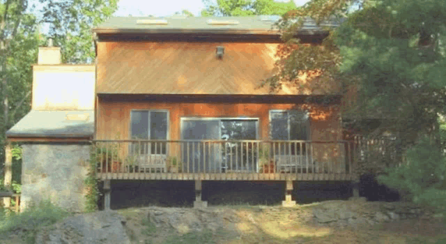 a wooden house with a large deck and a chimney