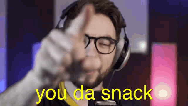 a man with glasses and headphones is giving a thumbs up with the words you da snack behind him