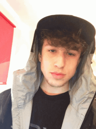 a young man wearing a black hat and a jacket with the letter a on it