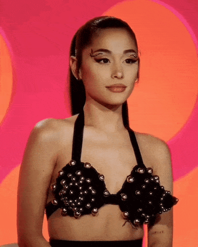 a woman wearing a black bra with silver beads