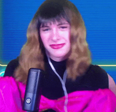 a woman in a pink jacket is holding a microphone with a g on it