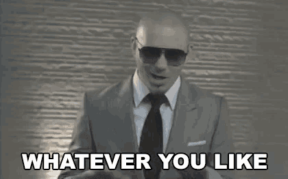 a man in a suit and tie is saying `` whatever you like '' while wearing sunglasses .