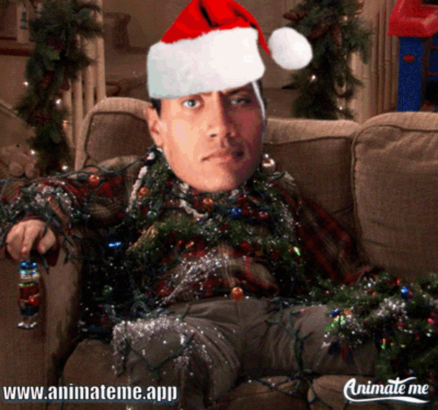 a man wearing a santa hat is sitting on a couch surrounded by christmas lights