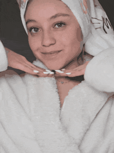 a woman wearing a white robe and a towel around her head