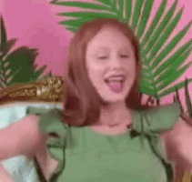 a woman in a green dress is making a funny face .