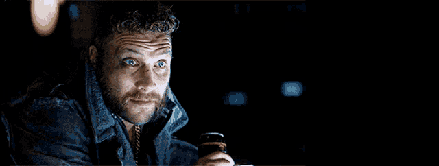 a man with a beard is holding a beer in his hand
