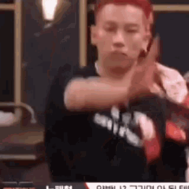a man with red hair is making a funny face with his hands .