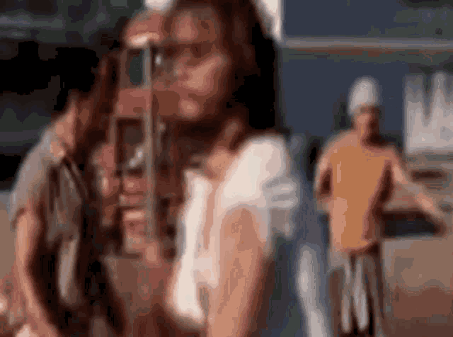 a blurry picture of a woman standing in front of a man in a yellow shirt .
